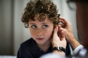 Junge mit Locken und Hörgerät